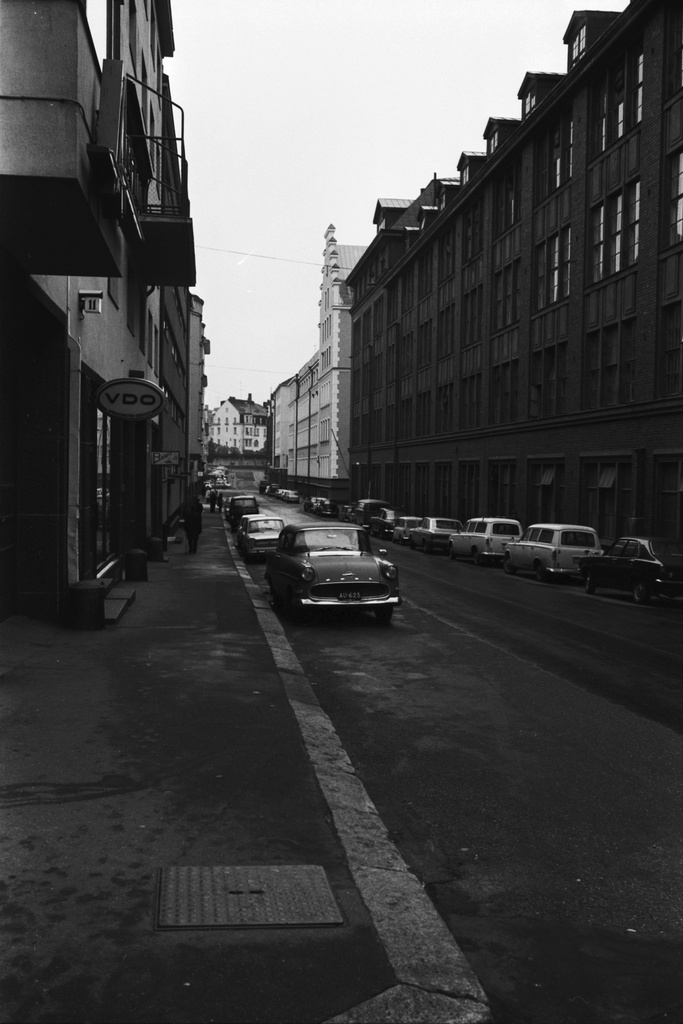 Punavuori. Näkymä Perämiehenkadulta Merimiehenkadun kulmasta etelään, Tehtaankadun suuntaan. Oikealla entinen Suomen Kaapelitehtaan tuotantolaitos (Merimiehenkatu 36-40.  Perämiehenkatu 10-12). Kadulla pysäköityjä autoja, lähimpinä Opel Rekord, Sunbeam Avenger ja kaksi Peugeot 403 -farmariautoa.