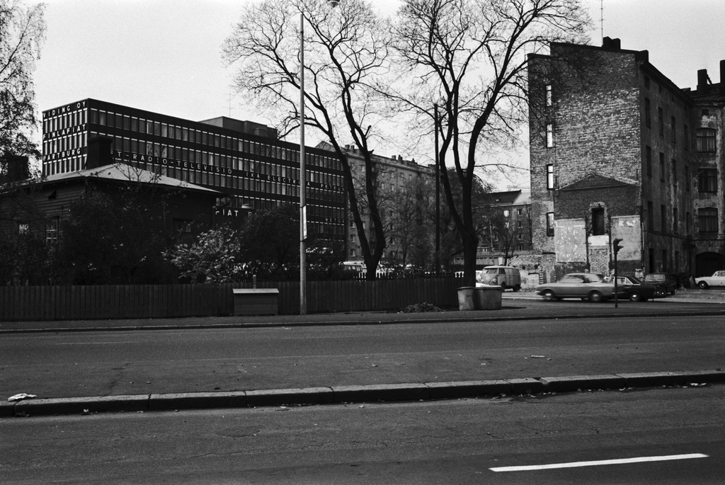 Näkymä Ruoholahdenkadun laidalta luoteeseen, Lastenkodinkadun suuntaan. Vasemmalla Ruoholahden villoja lauta-aidan takana. Taustalla oikealla ränsistynyt kerrostalo Lastenkodinkatu 1, vasemmalla Lastenkodinkatu 5 toimistotalo.