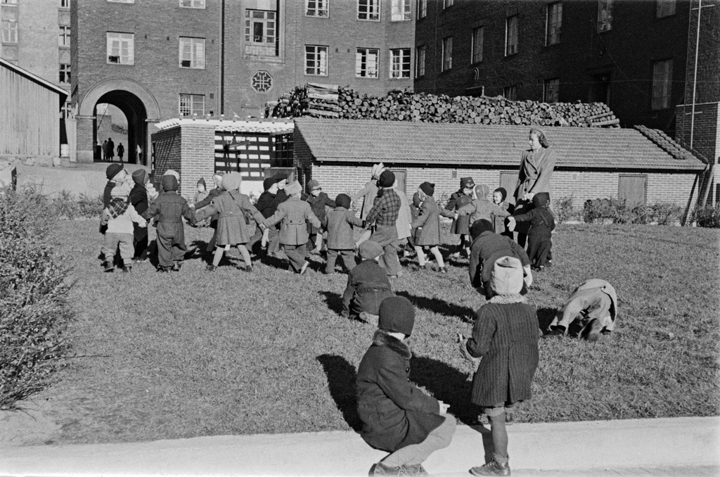 Elannon päiväkodin lapsia päiväkodin pihalla. Neljäs linja 3 - 5 ja Viides linja 4 väliin jäävä sisäpiha. Korttelia ympäröivissä taloissa oli Elannon työntekijöiden asuntoja. Taustalla Viides linja 4.