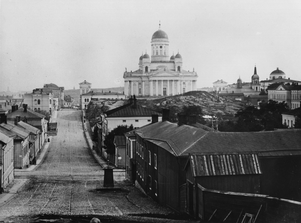 Kruununhaka. vas. Nikolainkatu (= Snellmaninkatu) 16-10 ja  27-15. Etualalla oikealla numero 8, entinen Nuuskamyllynmäki. Taustalla Nikolainkirkko.