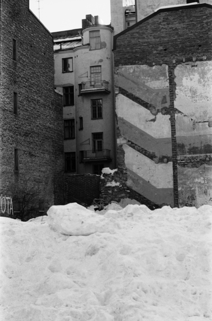 Snellmaninkatu 19, 17. Näkymä Snellmaninkatu 19:n puretun talon lumiselta tontilta. Snellmaninkatu 17:n talon seinässä näkyvillä puretun talon kerrosjakoa.