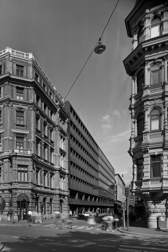 Kluuvikatu 2 vas. ja 4 Pohjoiseplanadilta nähtyinä.  Kluuvikatu 2:n (- Pohjoisesplanadi 29), hotelli Kämpin talon suunnitteli Theodor Höijer ja se valmistui 1887. Kluuvikatu 4:n rakennusvuosi on 1962 suunnittelijoinaan Antero Pernaja ja Thomas Sandell. Oik. on Kuuvikatu 1 (-Pohjoisesplanadi 25-27), Grönqvistin talo. Se valmistui 1883, sen suunitteli Theodor Höijer.