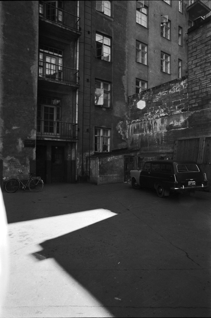 Kaarlenkatu 10. Näkymä Kaarlenkatu 10:n ränsistyneestä pihapiiristä. Oikealla Opel Rekord tai Opel Olympia -farmariauto, vasemmalla miesten polkupyörä.