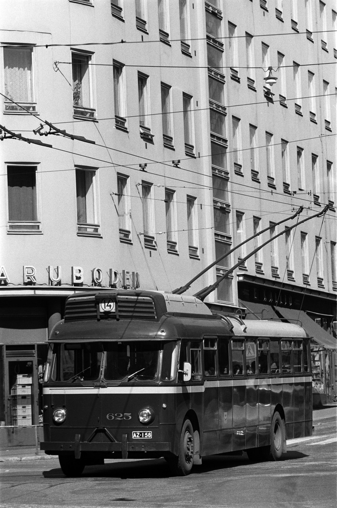 Johdinautojen viimeinen liikennöintikevät Helsingissä. Linjan 14 johdinauto numero HKL 625 Malminrinteen ja Lapinlahdenkadun kulmassa matkalla kohti Eiran päätepysäkkiä Laivurinkadulla. Taustalla Varubodenin elintarvikemyymälä. Johdinautoliikenne päättyi 14.6.1974.