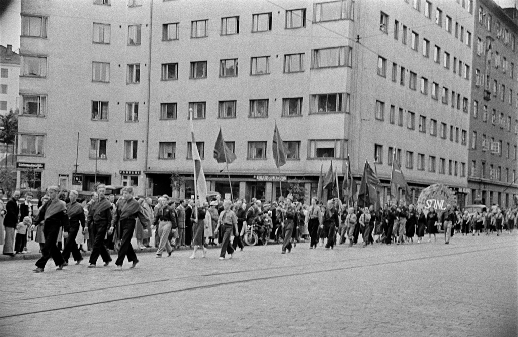 Rauhanmarssi ja yleisöä Helsinginkadulla Harjutorin kohdalla, Suomen Demokraattisen Nuorisoliiton (SDNL) jäseniä kantamassa lippuja ja seppelettä.