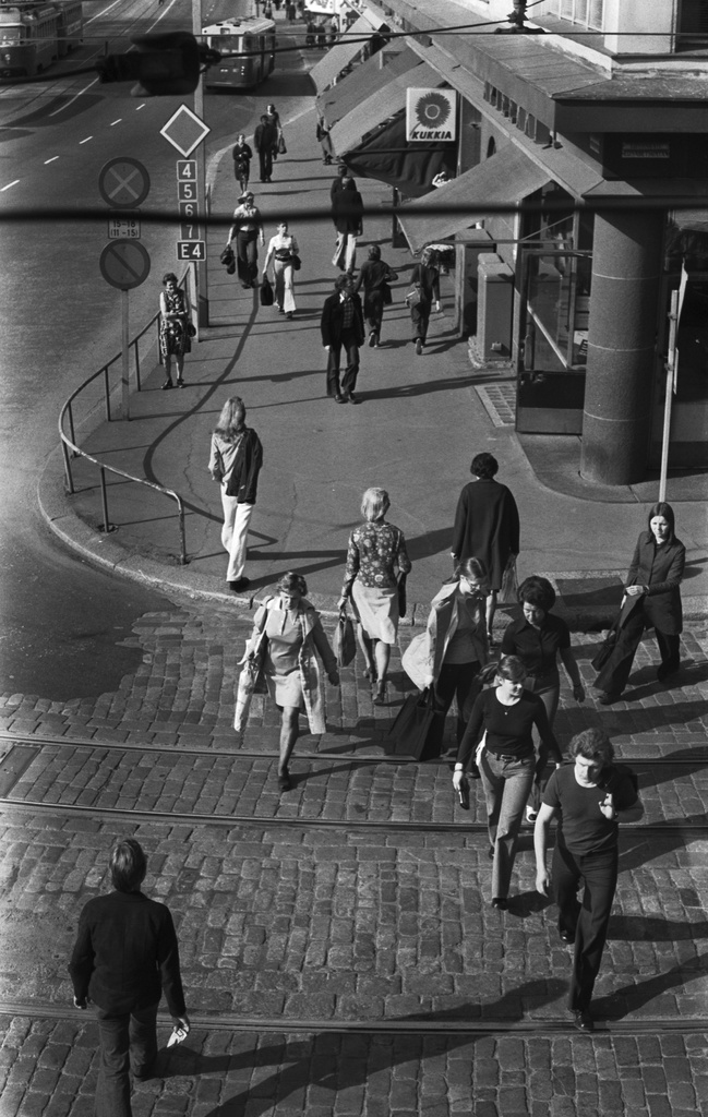 Unioninkatu 39. Jalankulkijoita ylittämässä Liisankatua Unioninkadun kulmassa iltapäivän ruuhka-aikaan. Näkymä kiviaidan päältä Siltasaaren suuntaan.