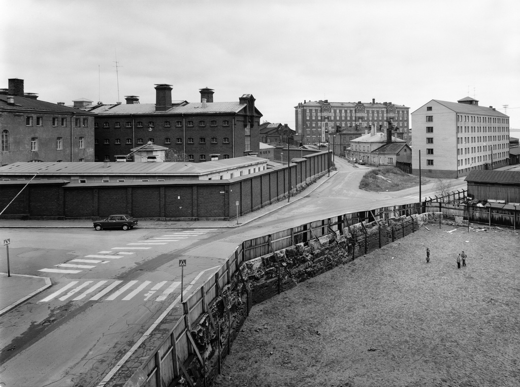 Vyökatu 1-3, Lääninvankila (vas.). Linnankatu 9, Yömaja (oik.). Linnankuja 2,3 (kesk.). Taustalla on Lutikkalinna, Puolipäivänkatu 4, etualalla Katajanokan kansakoulun pihaa.