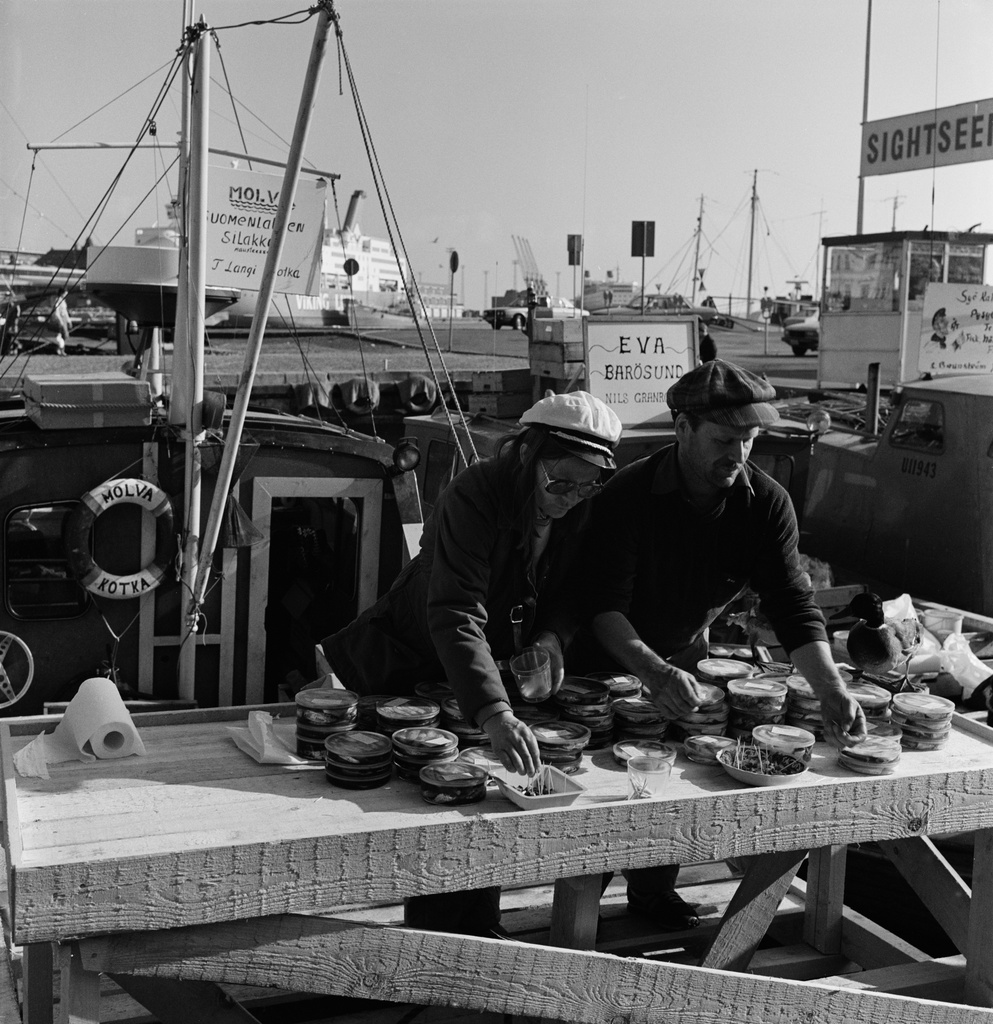 Silakkamarkkinat Eteläsatamassa. Maustettua silakkaa asetellaan myyntipöydälle kalastajaveneestä Kolera-altaan reunalla.