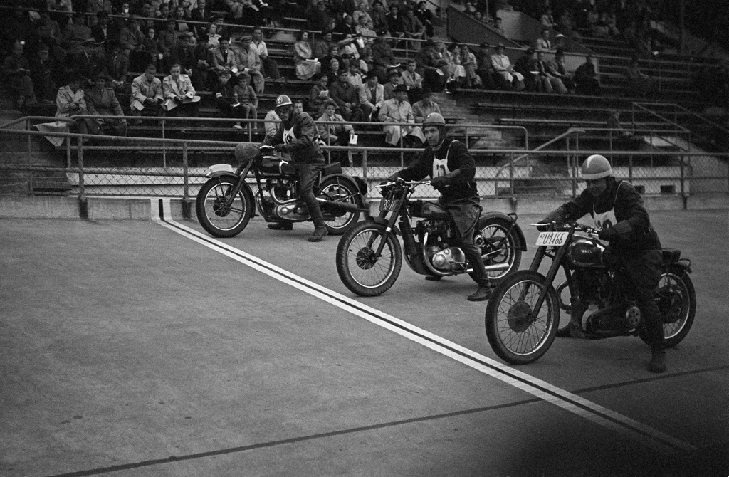 Velodrom, Helsingin pyöräilystadion, moottoripyöräkilpailut. Kolme kilpailijaa lähdössä, taustalla katsomo ja yleisöä.