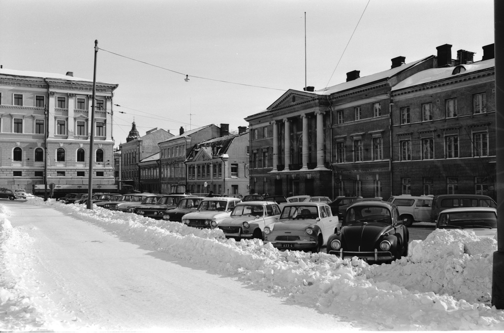 Kruununhaka Aleksanterinkatu. Pysäköityjä autoja lumisen Senaatintorin laidalla Aleksanterinkadun varrella.