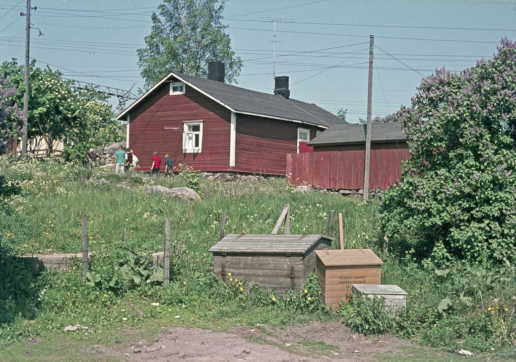 Puisia postilaatikoita Viikintien varrella. Puinen asuinrakennus on Kalastajanpolku 1 (kortteli 36035).
