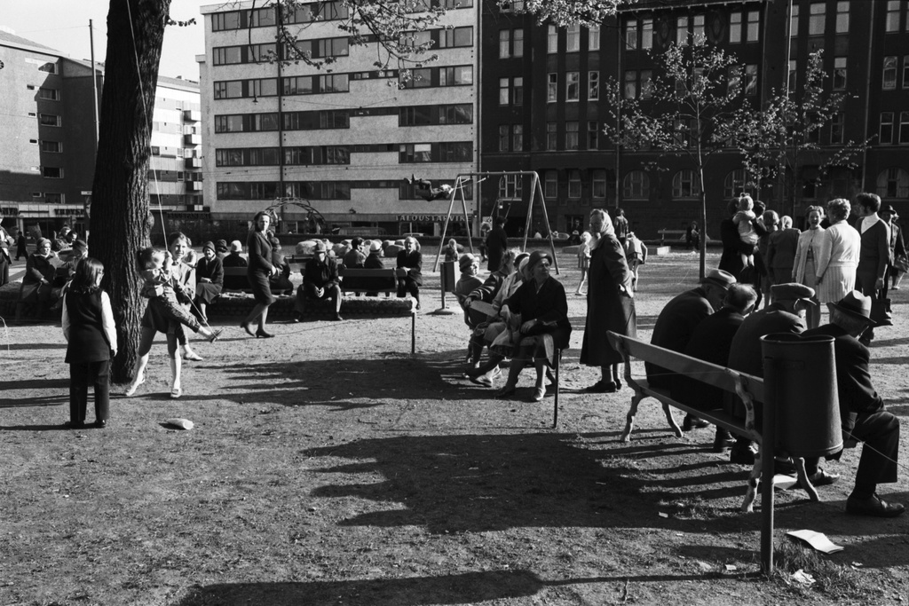 Karhupuisto. Ihmisiä istumassa penkeillä Karhupuistossa puistotapahtuman aikaan.