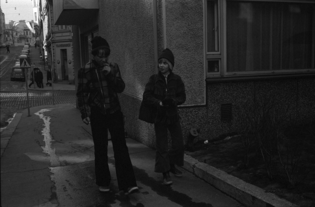 Kruununhaka, Meritullinkatu 23. Kaksi poikaa kävelemässä Meritullinkadulla, taustalla Liisankadun kulmassa Varubodenin ruokakauppa.