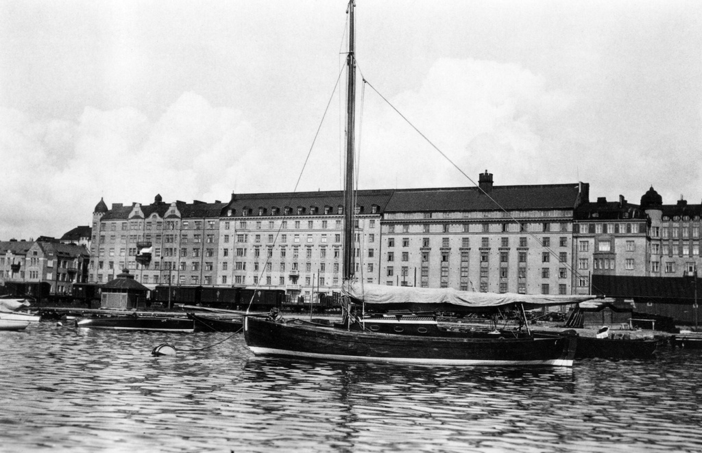 Merisatama (vasemmalta: Merikatu 11, 9, 7, 5, 3). Edustalla satamaan kiinnitettyjä veneitä. Takana satamarata ja tavaravaunuja.