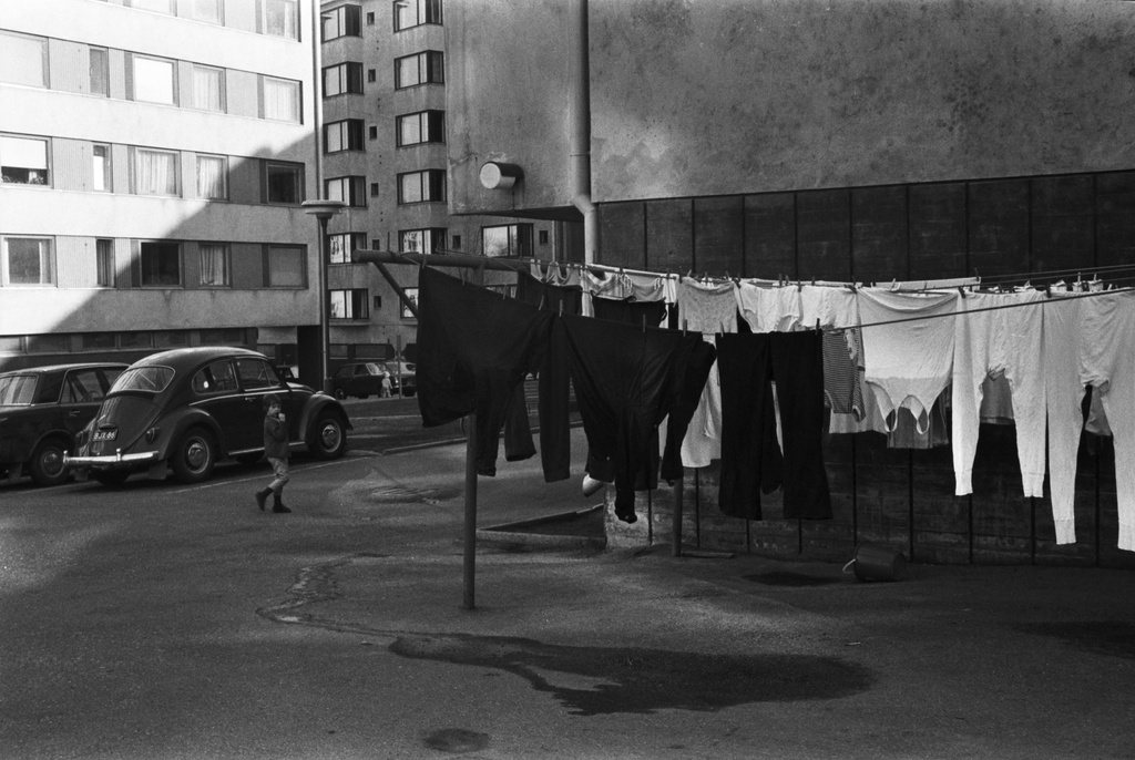 Neljäs linja 17, 19. Neljäs linja 17-19:n pihapiiriä, jossa pyykkiä kuivumassa narulla, lapsi sekä pysäköityjä autoja. Taustalla Neljäs linja 22.