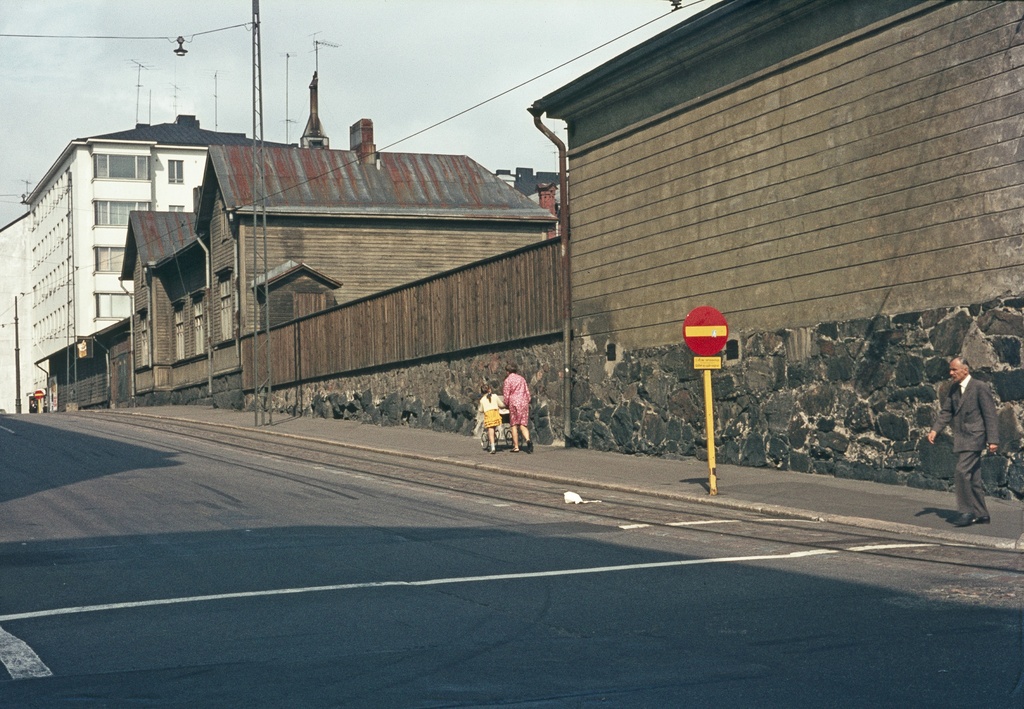 Hietalahdenkatu 1, 3. oikealla Kaartin lasaretin sotilassairaalamiljöötä. Vasemmalla nainen ja tyttö lastenvaunujen kanssa, oikealla mies ylittämässä tietä.