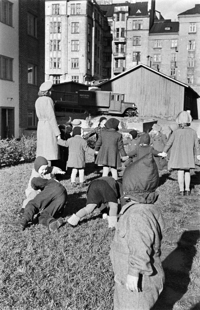 Elannon päiväkodin lapsia päiväkodin pihalla. Neljäs linja 3 - 5 ja Viides linja 4 väliin jäävä sisäpiha. Korttelia ympäröivissä taloissa oli Elannon työntekijöiden asuntoja ja Elannon lastentarha. Taustalla Viides linja 5 - 9.