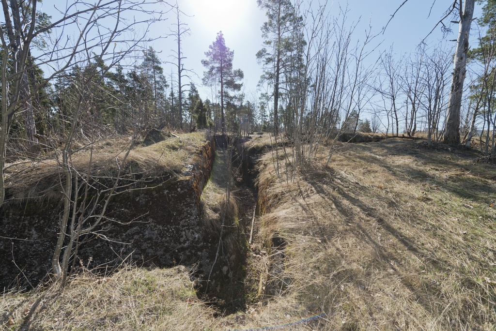 Länsimäki. Ensimmäisen maailmansodan aikainen maalinnoitus, puolustusasema II:8 Länsimäessä, Vantaalla. Kuvassa näkyy kallioon louhittua, betonilla tuettua taisteluhautaa aseman pohjoisosassa. Rintasuojan alaosassa on torjuntasuunnan puolella ampumakoroke. Haudasta nousua helpottamaan on tehty pienet portaat, jotka jäävät miltei kokonaan aluskasvillisuuden alle piiloon. Kuvaussuuntana itä.