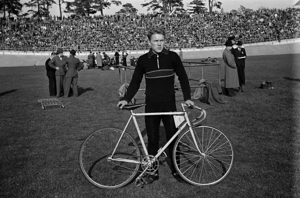 Velodrom, Helsingin pyöräilystadion, pyöräilykilpailut. Kilpailija ja polkupyörä, taustalla toimitsijoita ja katsomo.