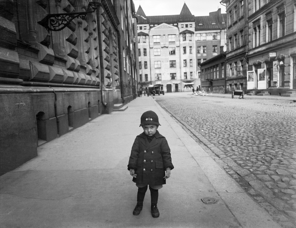 Eerikinkatu 1 - 4, taustalla Yrjönkatu 25. Lapsi kadulla. Eerikinkatu 4:ssä lihakauppa.