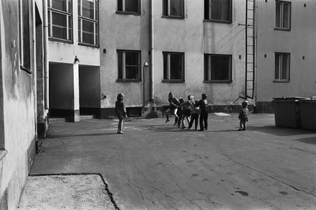 Hakaniemenkuja 2. Lapsia leikkimässä Hura hura häitä -leikkiä Hakaniemenkujan, Hakaniemenkadun, Näkinkujan ja Sörnäisten rantatien välisellä korttelipihalla.