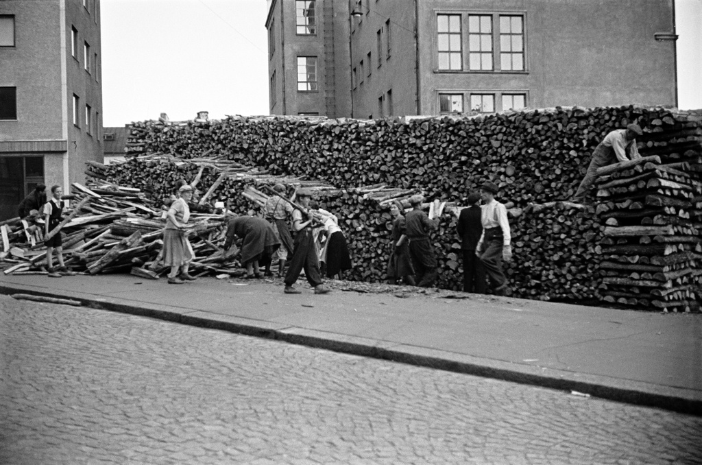 Halkopinojen kokoamista Agricolankadulla, aikuisia ja lapsia. Taustalla Porthaninkatu 17, 15 (=Kallion yhteiskoulu).