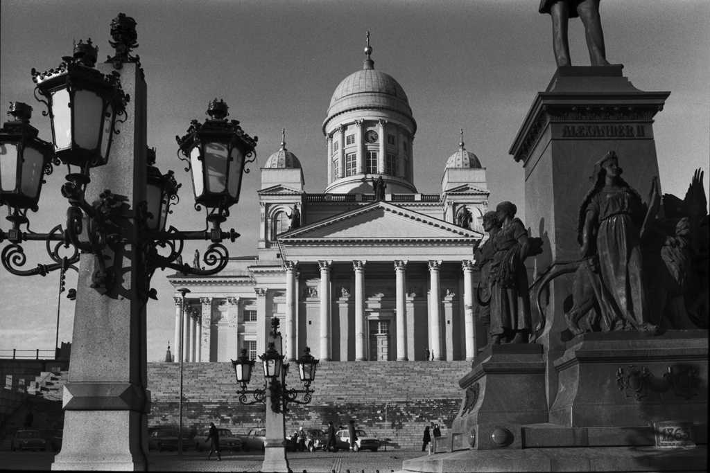 Senaatintori. Tuomiokirkko Aleksanterinkadun suunnalta. Etualalla Aleksanteri II:n patsaan jalustan juurella olevia veistoksia ja ympärillä olevia lyhtyjä.