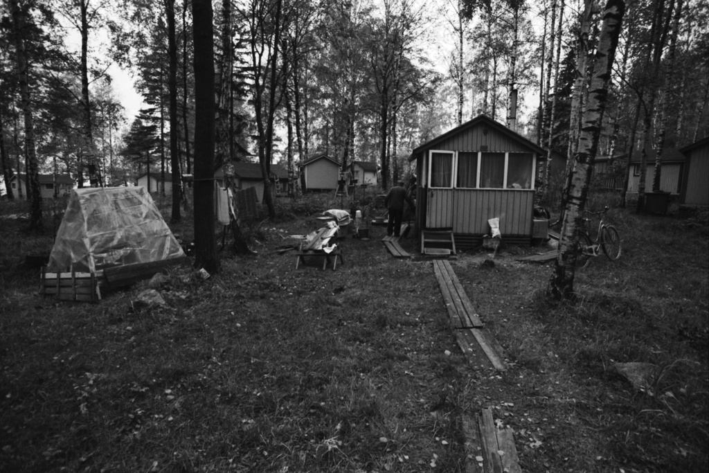 Kulosaari Näkymä syksyiseltä Kivinokan kesälumaja-alueella. Mies pitkospuilla pienen mökin seinustan vierellä.