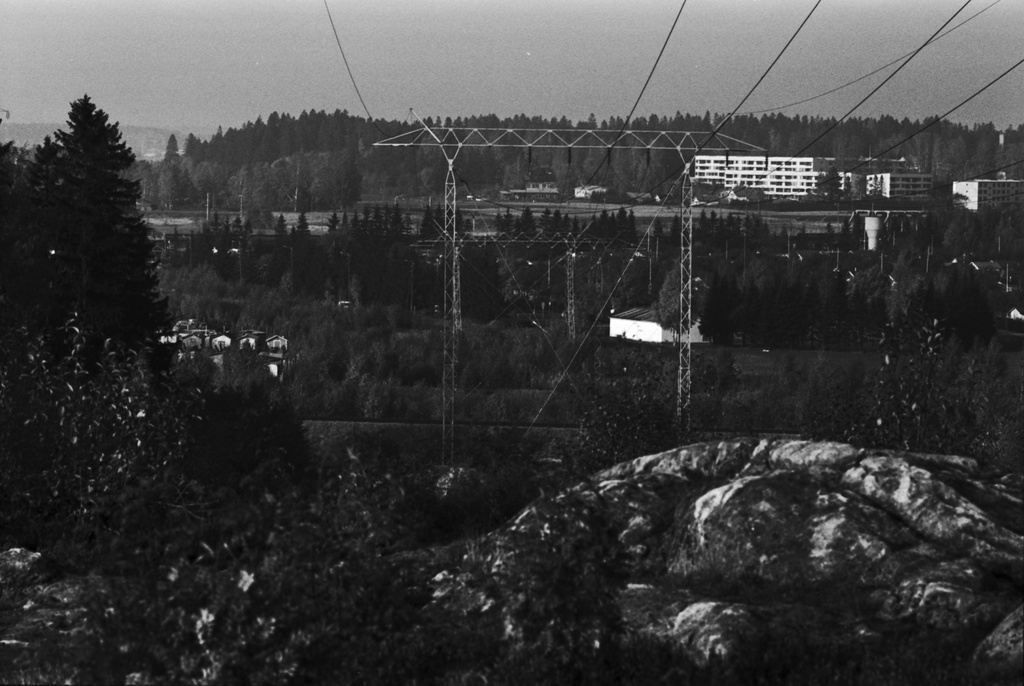 Näkymä Pirunkalliolta pohjoiseen Oulunkylän Veräjämäessä. Kallion reunan takana Herttoniemen satamarataa. Keskellä voimajohtolinja, oikealla Oulunkylän siirtolapuutarhaa. Taustalla oikealla pääradan silta Vantaanjoen yli.