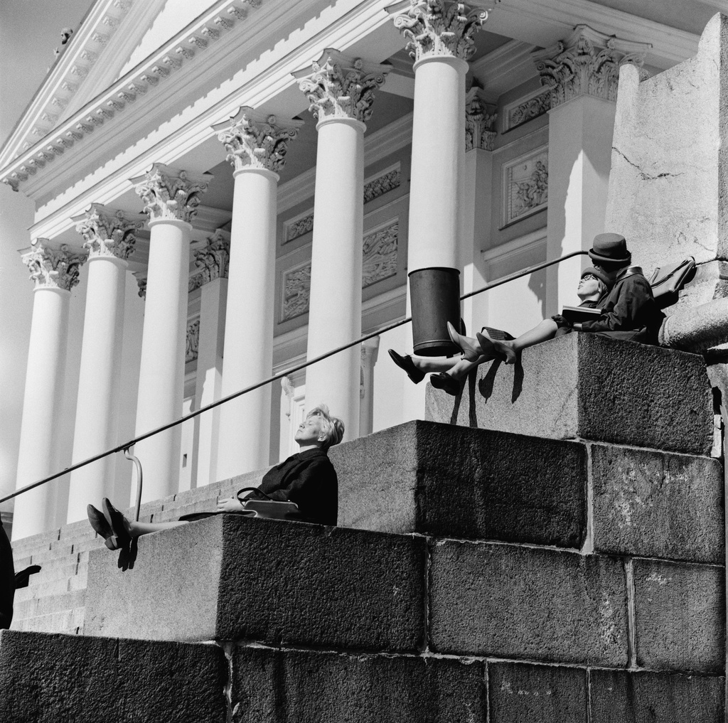 Ihmisiä istumassa Tuomiokirkon portailla.