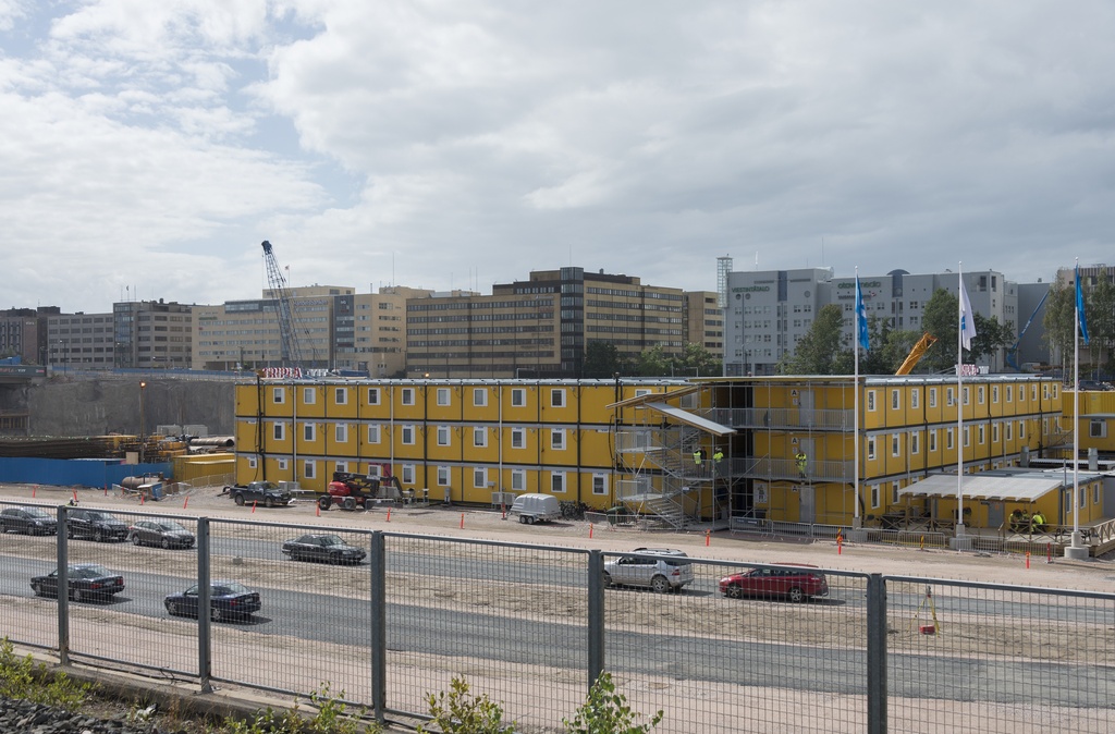 Ratapihantie 6, Pasilan asema. Näkymä Fredikanterassin ja kauppakeskus Triplan työmaalle aseman laiturilta. Työmaalla runsaasti keltaisia työmaakontteja. Taustalla Pasilankadun toimistorakennuksia.