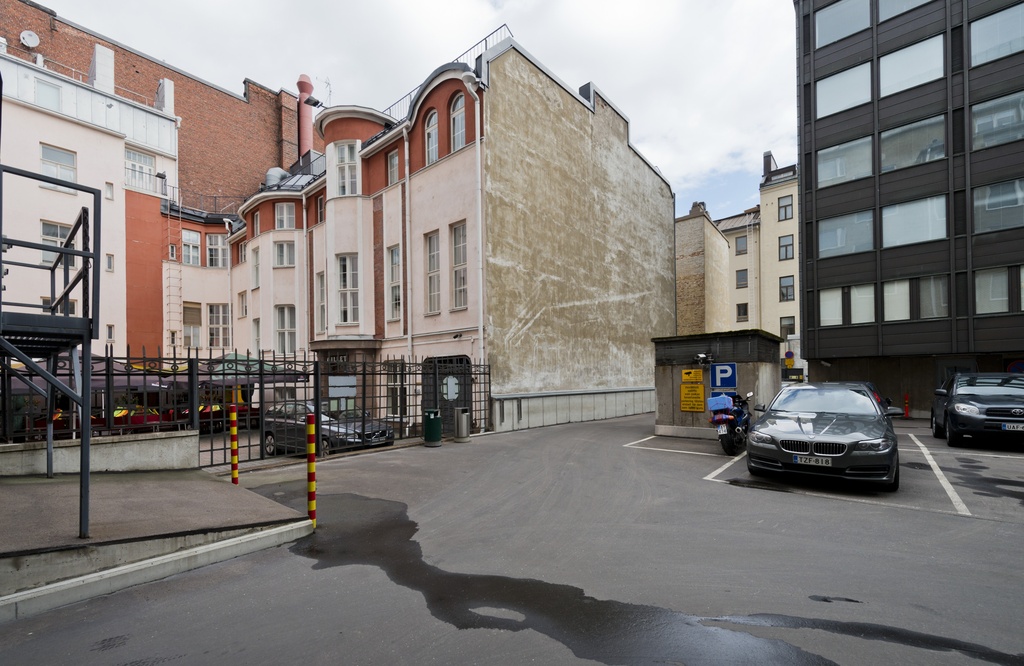Kasarmikatu 21, Rakennusviraston sisäpiha. Paikoituskäytössä. Vasemmalla aidan takana ravintola Cantina Westin terassi.