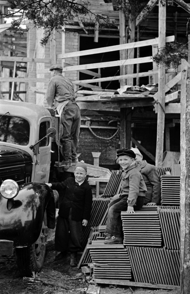 Mannerheimintie 93. Lehtikuusentie 2. Asuntoyhteistalo Oy;n eli Naisten talon rakennustyömaa. Lapsia katselemassa todennäköisesti saunarakennuksen rakennustyömaata kattotiilikasoilla istuen.