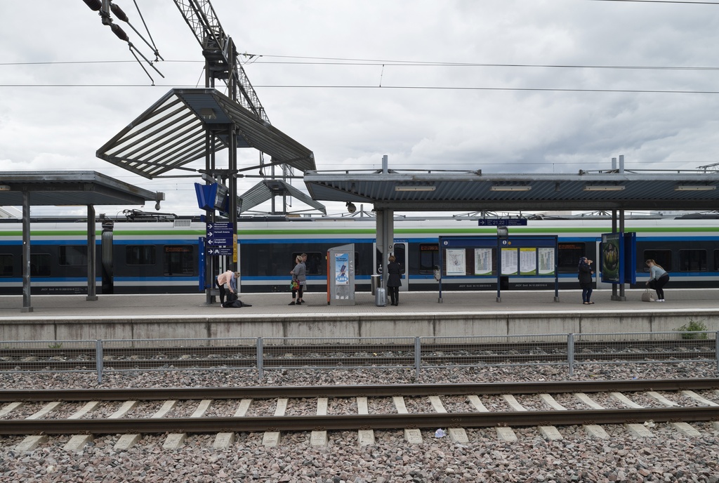 Ratapihantie 6, Pasilan asema. Näkymä aseman laitureille 6 ja 7. Lähijuna E saapumassa asemalle. Matkustajia odottamassa saapuvaa junaa.