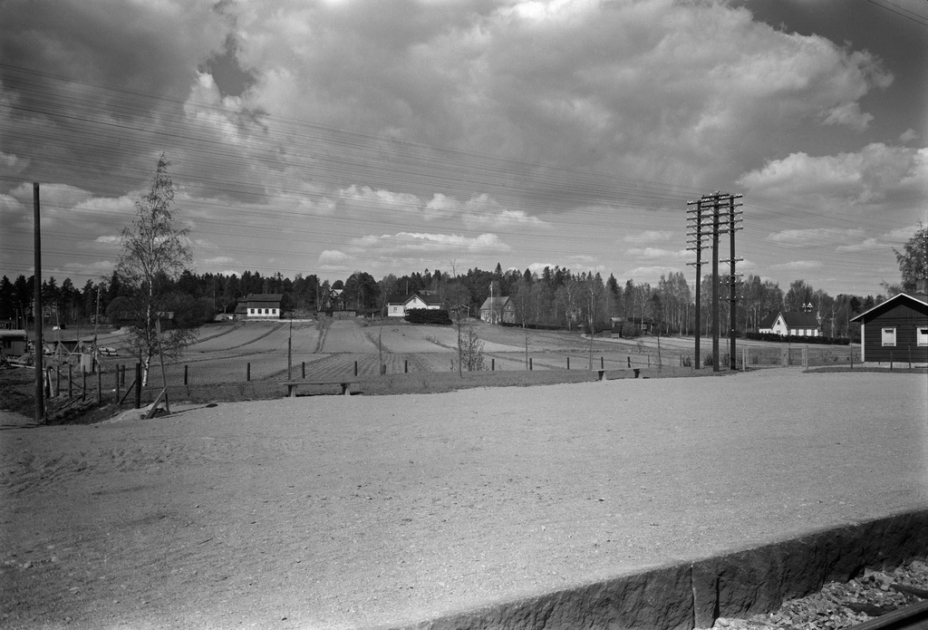 Oulunkylä, näkymä rautatieaseman raiteilta luoteeseen, kohti Kottbyn tilaa. Peltojen takana vasemmalla tilan navetta ja keskellä päärakennus (Teinintie 25). Taustalla oikealla Oulunkylän vanha kirkko (Siltavoudintie 12).