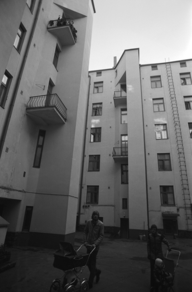 Liisankatu 9. Liisankatu 9:n pihan puolta. Nuori mies ja nainen lastenvaunujen kanssa.