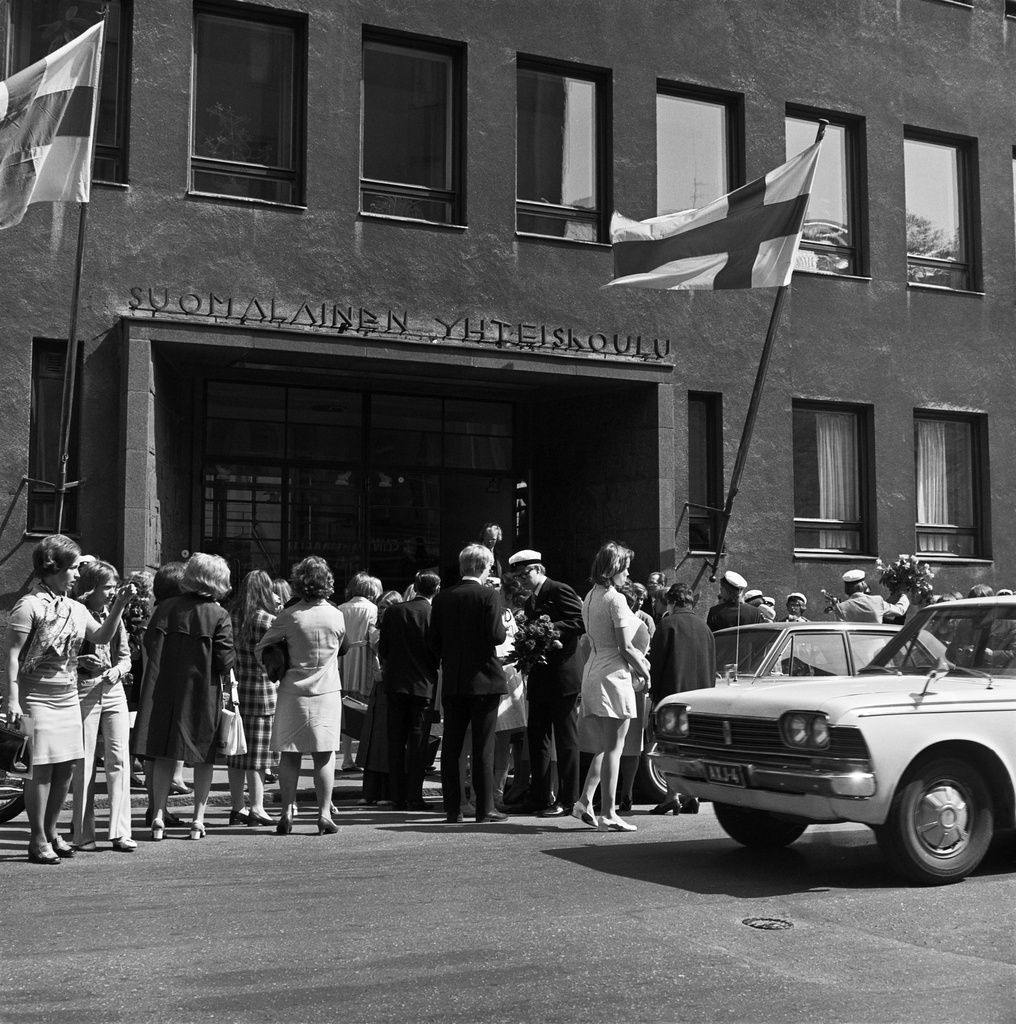 Suomalaisen yhteiskoulun uusia ylioppilaita koulunsa edustalla.