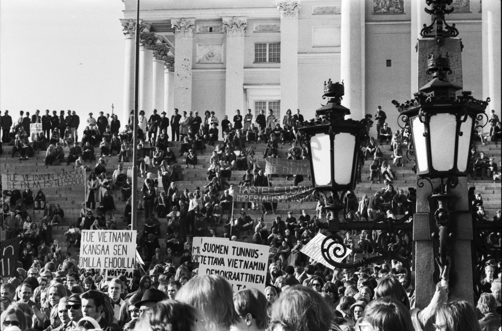 Hallituskatu 7. Vietnamin sodan vastaiseen mielenosoitukseen osallistuvia ihmisiä kokoontuneena Senaatintorille sekä Tuomiokirkon portaille ennen lähtöä marssille kohti Yhdysvaltain suurlähetystöä.