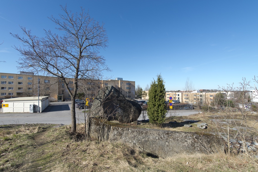 Länsimäki. Ensimmäisen maailmansodan aikainen maalinnoitus, puolustusasema II:8 Länsimäessä, Vantaalla. Kuvassa näkyy kallioon louhittua, betonilla tuettua yhdyshautaa aseman eteläosassa. Haudan eteläpään vierellä on erittäin kookas kivenlohkare, johon on maalattu valkoinen tekstigraffiti. Kuvan oikeassa laidassa hauta katkeaa pieneen kuoppaan. Pohjalla kasvaa puita. Taustalla näkyy kerrostaloja sekä parkkipaikka. Kuvaussuuntana lounas.
