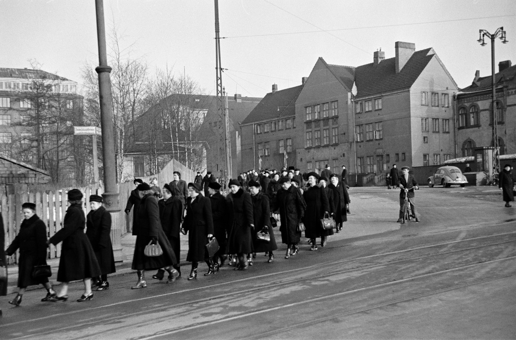 Miina Sillanpään hautajaiset. Hautasaatto kääntymässä Kalmistokadulle (=Mechelininkatu). Taustalla vasemmalla Eteläinen Rautatiekatu 20, oikealla Marian sairaala.