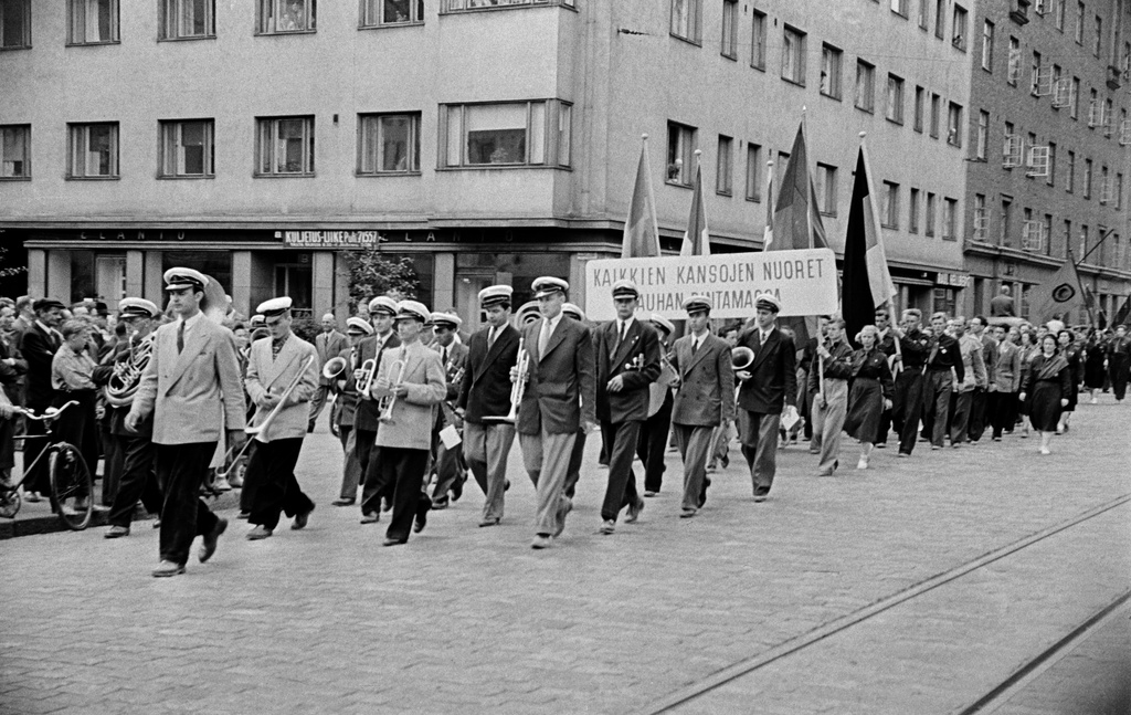 Rauhanmarssi ja yleisöä Helsinginkadulla Harjutorin kohdalla. Puhallinsoittajia, taaempana kyltti "Kaikkien kansojen nuoret rauhan rintamassa".