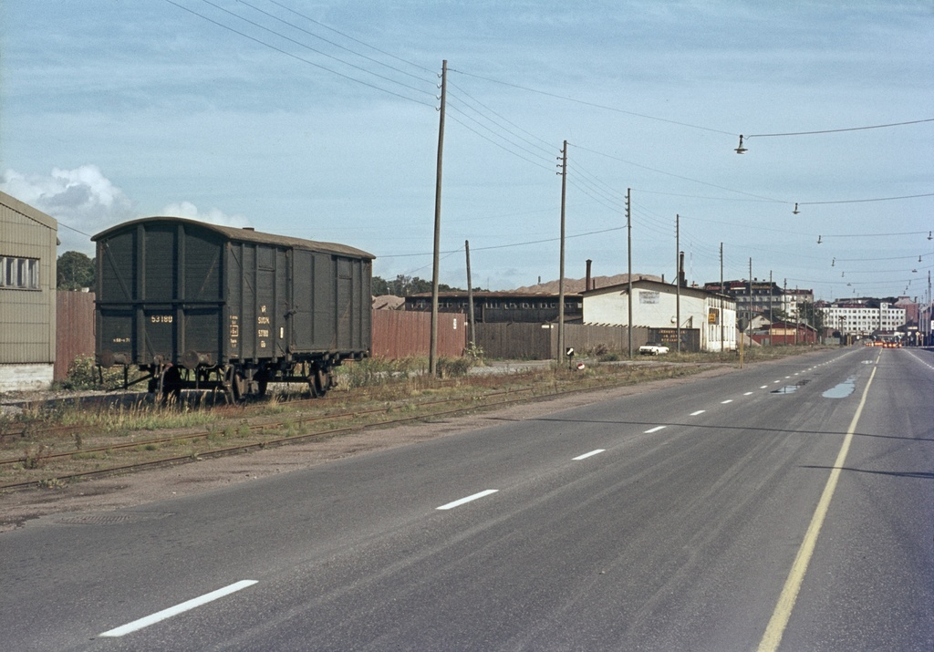 Ruoholahti, näkymä Itämerenkatua pitkin itään päin. Vasemmalla junanvaunu sekä Itämerenkadun rakennuksia, horisontissa Ruoholahdenkatu 23 ja 24 (Köydenpunojankatu 15).