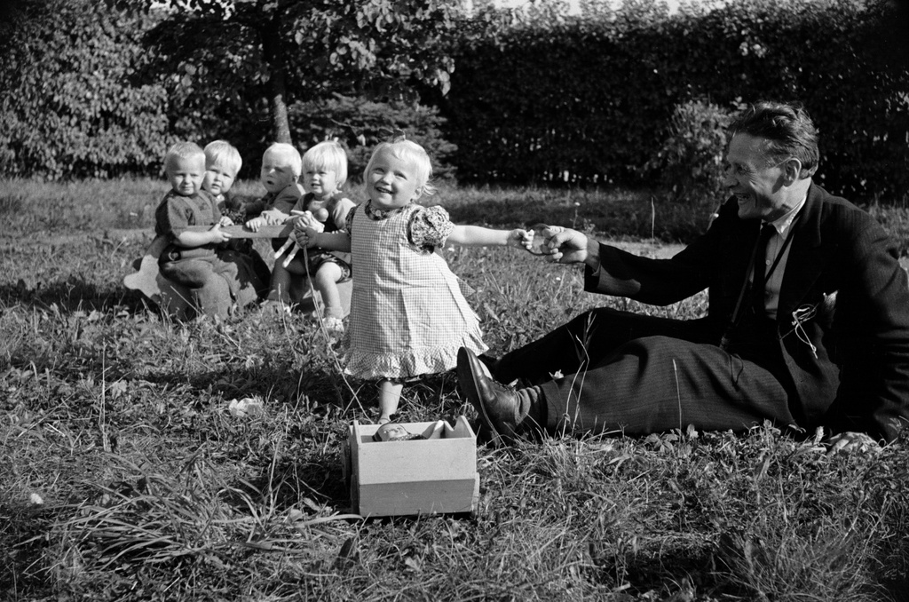 Tyttö leikkii valokuvaaja Väinö Kanniston kanssa Aunelan lastenkodin pihalla