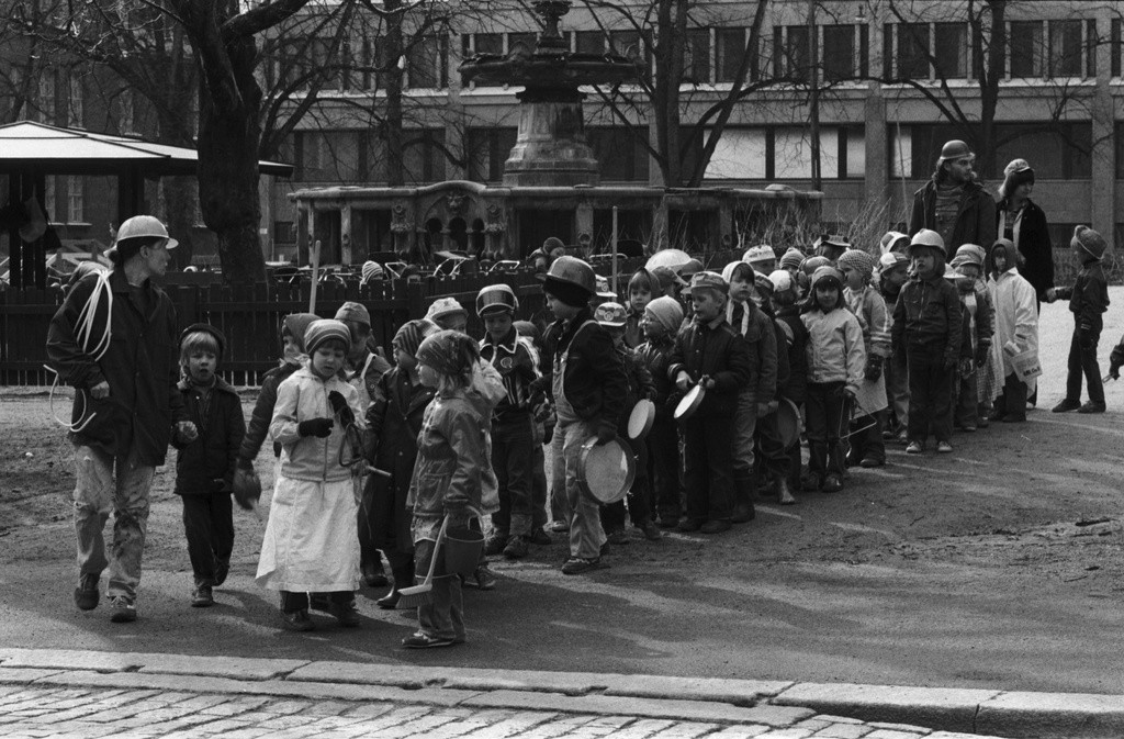 Rauhankatu. Lapsia ja aikuisia jonossa harjakaisaiheisissa vappukarnevaaliasuissaan Säätytalonpuistossa lähdössä päiväkoti Virkkulaan oikokadulle.