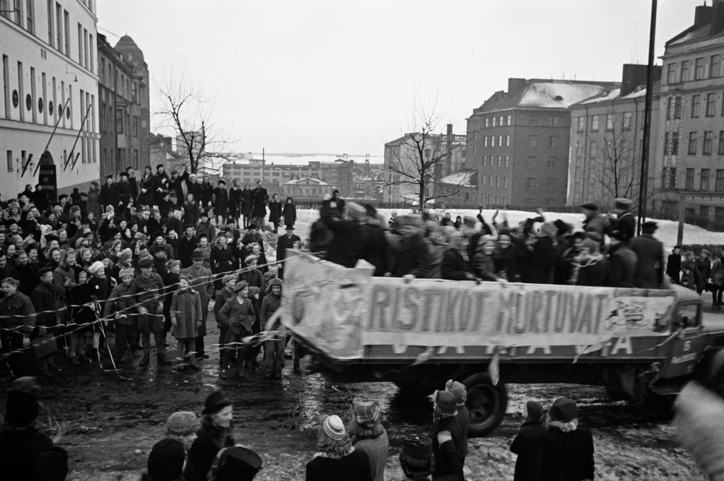 Kallion yhteiskoulun abiturientit Porthaninkadulla lähdössä penkinpainajaisajelulle. Taustalla Alli Tryggin puisto, alhaalla Hämeentie ja Haapaniemen urheilukenttä (=Väinö Tannerin kenttä).