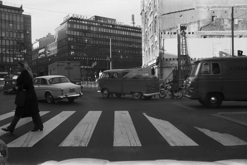 Liikennettä Keskuskadun ja Pohjoisesplanadin kulmassa. Taustalla Stockmannin tavaratalon uudisrakennuksen tontti. Näkymä auton ikkunasta Mannerheimintien suuntaan.