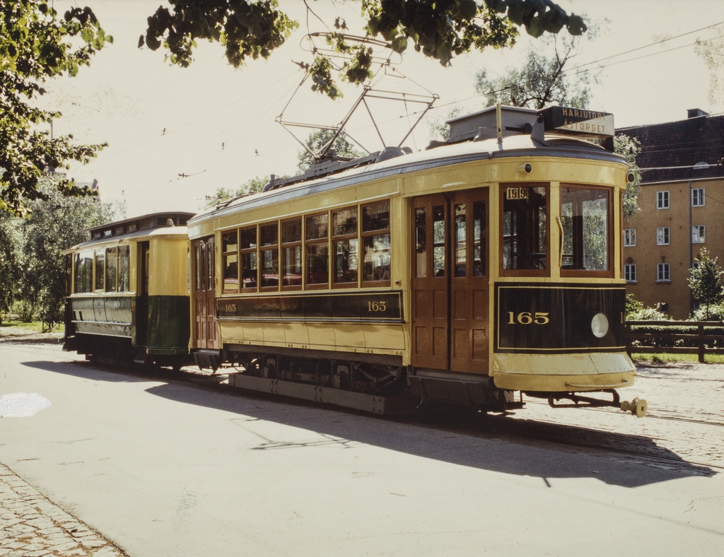 Vanha raitiovaunun, moottorivaunu (Museovaunu HRO-165, valmisettu 1920) ja perävaunu (Museovaunu HKL-615, valmistettu 1916), Vallilan varikon ulkopuolella kesällä. Vaunussa lukee Harjutori, Åstorget.