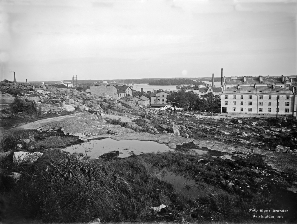 Näköala Agricolankatu 8:n tontilta itään Itäisen Viertotien yli kohti Sörnäisten rantaa. Oikealla kivitalo Pengerkatu 11. Taustalla Sompasaari ja Hanasaari.