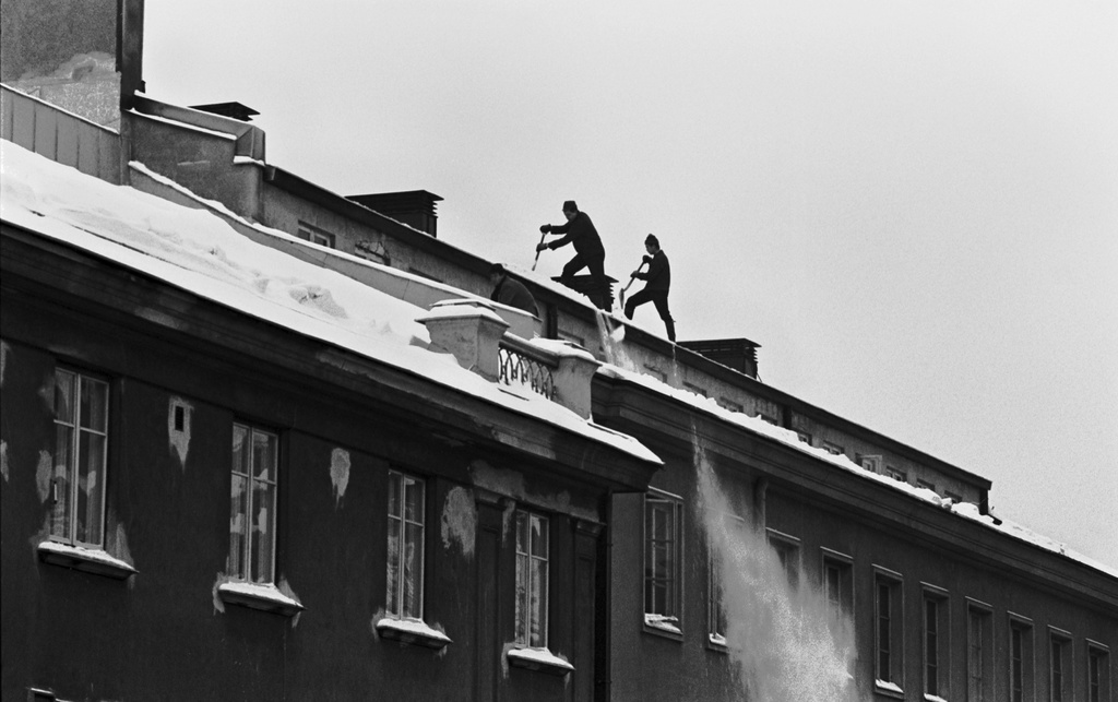Liisankatu 8. Miehiä luomassa lunta Liisankatu 8:n kerrostalon katolta.