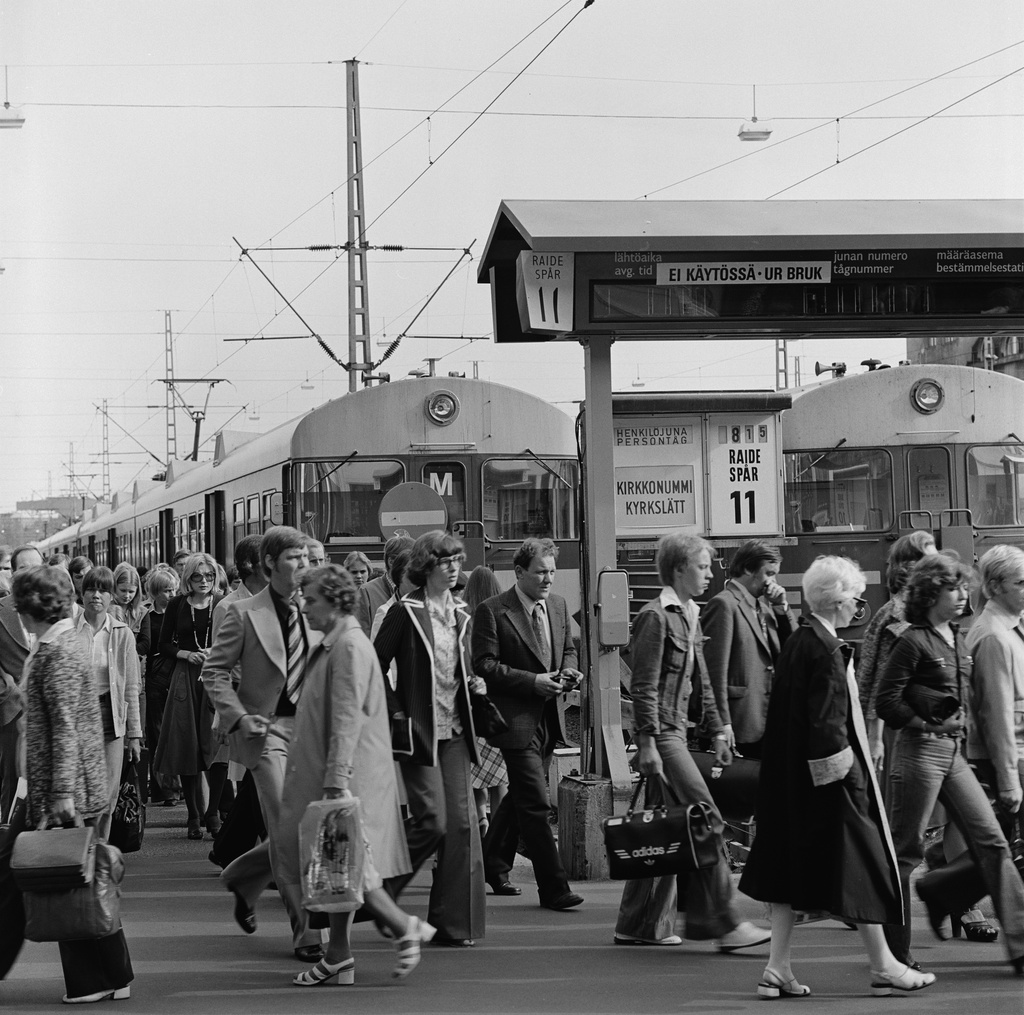 Matkustajia ja juna Helsingin rautatieasemalla.